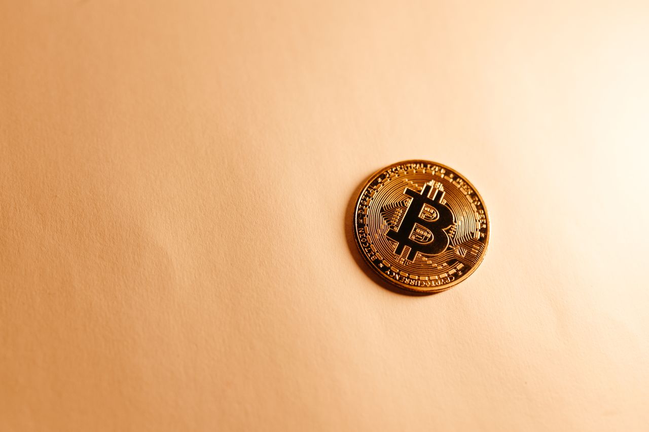 Home Close-up of a Bitcoin coin on a soft, neutral background representing the digital currency concept.